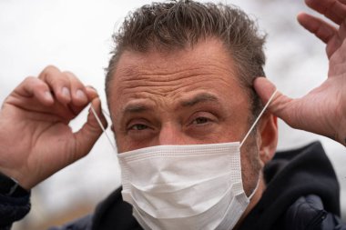 Coronavirus sırasında maske takan beyaz bir adam.