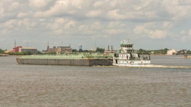 Bir mavnayı iten römorkör güneşli bir günde limanı fırlatır.