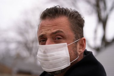 Coronavirus sırasında maske takan beyaz bir adam.