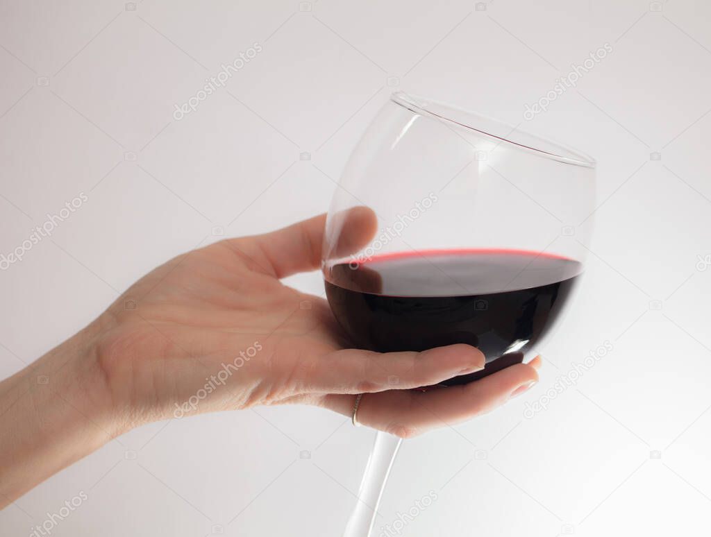 woman's hand pouring water from a wineglass. isolated on a white background.