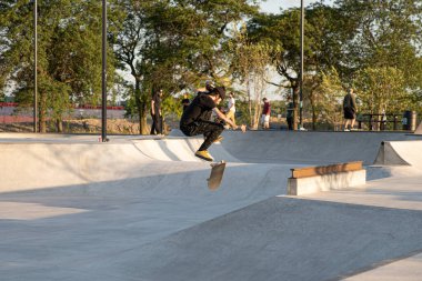 Detroit, Michigan, ABD - 08.09.2019: Kaykaycılar gün batımında şehir kaykay parkında numaralar deniyor