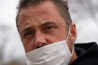 Coronavirus sırasında maske takan beyaz bir adam.