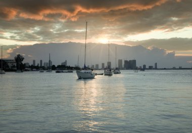 Güneş ışınları bulutların arasından körfezdeki gemilere doğru parlıyor.