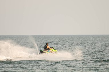 Dalgacılar ve su araçları gölde numaralar yapıyor..