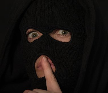 Çılgın gözlü maskeli biri sessiz olmanı emrediyor.