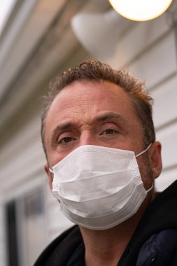 Coronavirus sırasında maske takan beyaz bir adam.