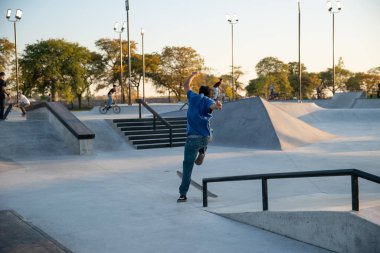 Detroit, Michigan, ABD - 10.20.2019: Detroit 'te gün batımında kaykay parkında antrenman yapan patenciler ve motorcular