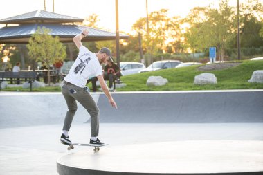 Detroit, Michigan, ABD - 10.07.2019: Patenciler ve motosikletçiler Detroit 'teki kaykay parkında gün batımında numara yapıyorlar