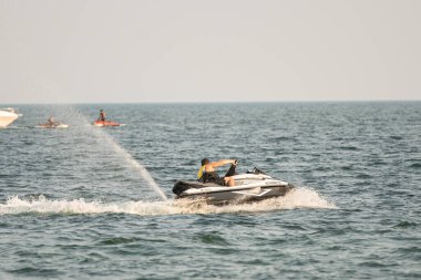 Dalgacılar ve su araçları gölde numaralar yapıyor..