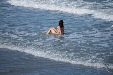 Kumsalda bikinili genç bir kadın.