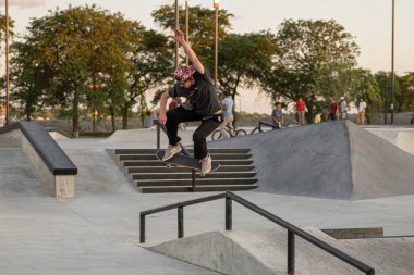 Detroit, Michigan, ABD - 08.09.2019: Kaykaycılar gün batımında şehir kaykay parkında numaralar deniyor