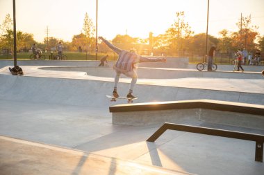 Detroit, Michigan, ABD - 10.20.2019: Detroit 'te gün batımında kaykay parkında antrenman yapan patenciler ve motorcular