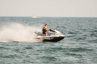 Dalgacılar ve su araçları gölde numaralar yapıyor..