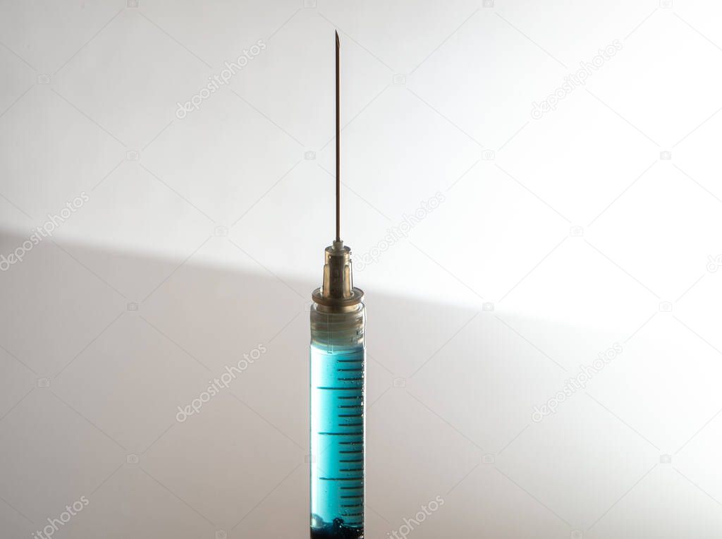 needle and syringe contain a blue liquid
