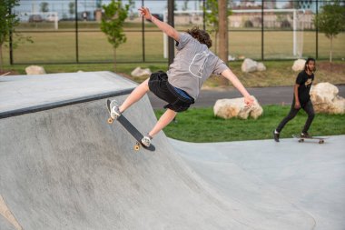 Detroit, Michigan, ABD - 08.07.2019: Detroit şehir merkezinde güneşli bir günde kaykay becerilerini geliştiren patenciler 