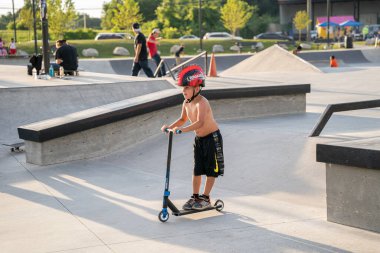 Patenciler numaralarını güneşli bir günde Detroit kaykay parkında, Kick scooter 'daki çocuk, Detroit, Michigan, ABD, 11 Ağustos 2020 