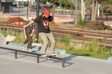 Detroit, Michigan, ABD 20.07.2020: Patenciler ve motorcular Detroit 'teki Corona Virüsü sırasında bir açık hava kaykay parkında numaralar deniyor.