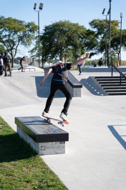 Detroit 'te güneşli bir öğleden sonra, açık hava kaykay pistinde patenciler...