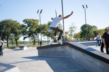 Detroit 'te güneşli bir öğleden sonra, açık hava kaykay pistinde patenciler...