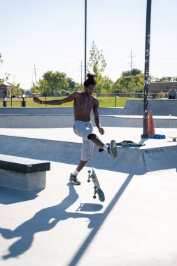 Detroit 'te güneşli bir öğleden sonra, açık hava kaykay pistinde patenciler...