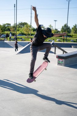 Detroit 'te güneşli bir öğleden sonra, açık hava kaykay pistinde patenciler...
