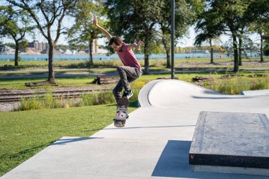 Detroit 'te güneşli bir öğleden sonra, açık hava kaykay pistinde patenciler...