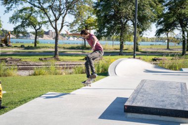 Detroit 'te güneşli bir öğleden sonra, açık hava kaykay pistinde patenciler...