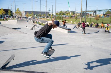 Detroit 'te güneşli bir öğleden sonra, açık hava kaykay pistinde patenciler...