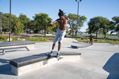 Detroit 'te güneşli bir öğleden sonra, açık hava kaykay pistinde patenciler...