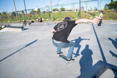 Detroit 'te güneşli bir öğleden sonra, açık hava kaykay pistinde patenciler...