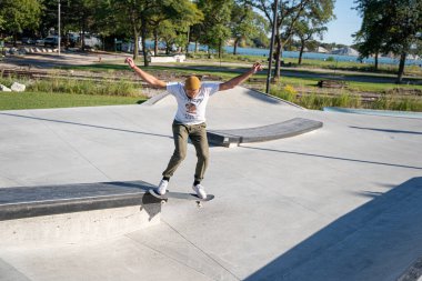 Detroit 'te güneşli bir öğleden sonra, açık hava kaykay pistinde patenciler...