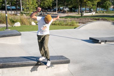 Detroit 'te güneşli bir öğleden sonra, açık hava kaykay pistinde patenciler...