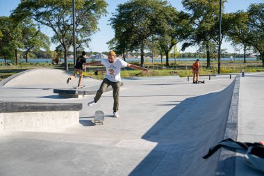 Detroit 'te güneşli bir öğleden sonra, açık hava kaykay pistinde patenciler...