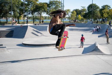 Detroit 'te güneşli bir öğleden sonra, açık hava kaykay pistinde patenciler...
