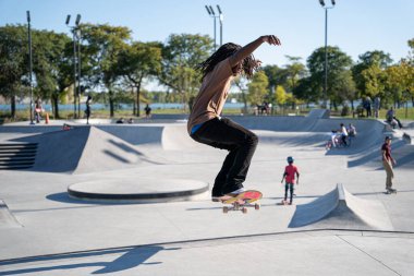 Detroit 'te güneşli bir öğleden sonra, açık hava kaykay pistinde patenciler...