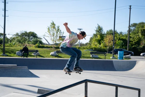 Detroit 'te güneşli bir öğleden sonra, açık hava kaykay pistinde patenciler...