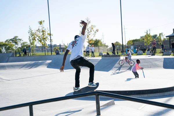 Detroit 'te güneşli bir öğleden sonra, açık hava kaykay pistinde patenciler...