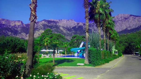 Dağlar, palmiye ağaçları, yüzme havuzu, Türkiye'de otel bölgesi