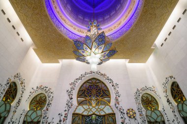 Cami'deki muhteşem mermer duvarların detayı. Renkli ışıklı kubbe, Abu Dabi, Birleşik Arap Emirlikleri