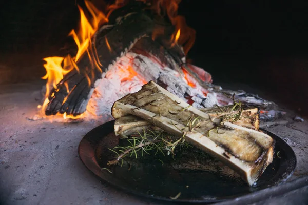 Dish of bone marrow roasted in a rustic wood-fired oven