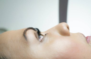 Kirpik uzatma prosedürü olan genç bir kadın.