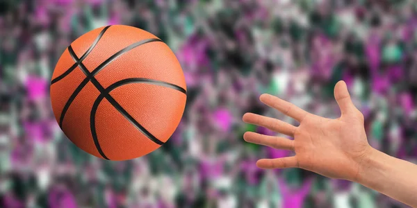 Basketball ball in the air. A hand reaches for the ball. Close-up. Sport games