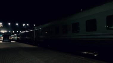 Tren yavaş yavaş kalkıyor. Demiryolu taşımacılığı. Gece vakti.