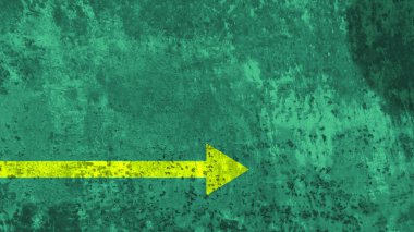 Yeşil arka planda sarı ok işaretçisi. Yakın plan. Demir materyal dokusu