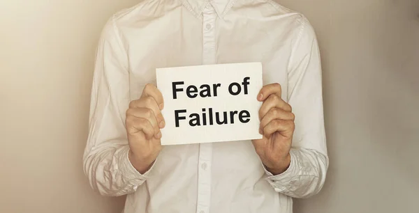 man take a paper with text Fear of Failure on the shirt with office background