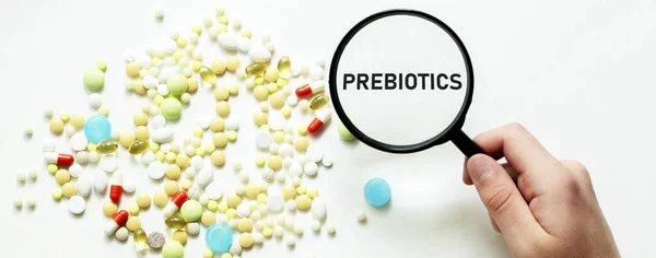 Χάπια Μεγεθυντικό Φακό Κείμενο Prebioticson Λευκό Φόντο — Φωτογραφία Αρχείου