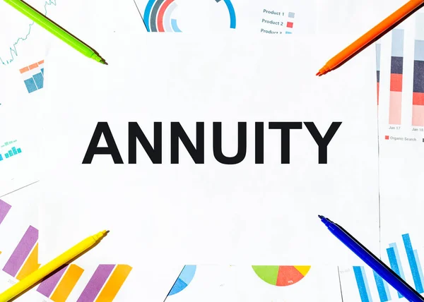 Grafiklerin arka planında metin ANNUITY yazılı beyaz kağıt parçası, çok renkli keçeli kalemler