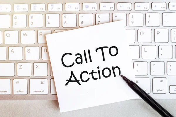 piece of paper with text Call To Action on the keyboard on a white background with a black felt-tip pen