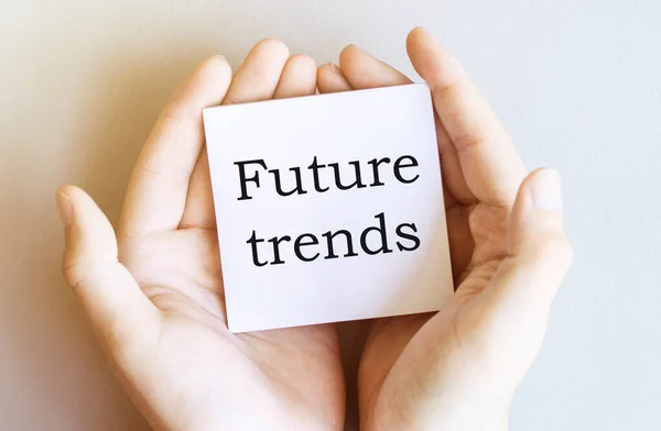 white paper with text Future trends in male hands on a white background