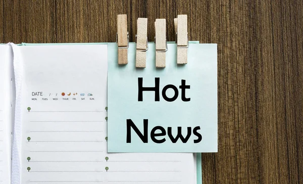 Hot Newsnotes paper and a clothes pegs on wooden background